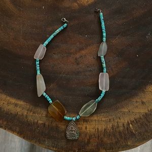 Buddha necklace with turquoise beads and sea glass or other stones.